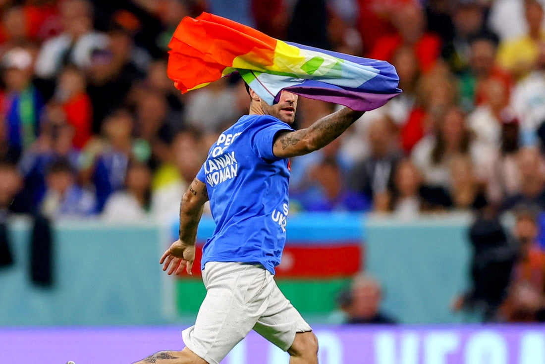 Protestor with rainbow flag runs across World Cup field during match